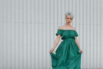 Emotional portrait of a beautiful blonde in green dress