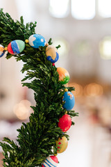 Green Christmas wreath with decorations on bright background.easter eggs