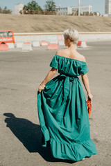 Emotional portrait of a beautiful blonde in green dress