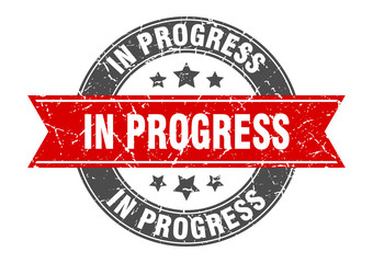 in progress round stamp with red ribbon. in progress