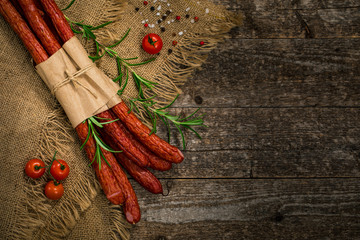 Thin Dry Smoked Polish Sausage on Wooden Background. Selective focus.