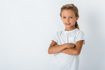 Fototapeta premium happy child standing with crossed arms on white