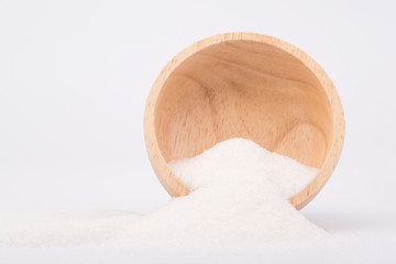 White granulated sugar contain in brown wooden bowl on white background. Unhealthy food concept.