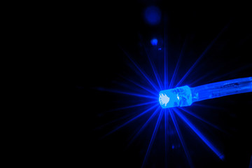 Fototapeta premium Blue color light bulb on the dark background.