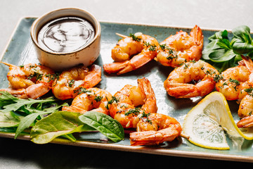 Delicious roasted shrimps on plate with lemon