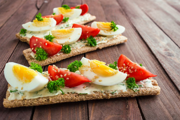 healthy sandwiches with crispbread cream cheese boiled eggs tomatoes close up
