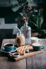 cup of coffee and flowers on wooden table