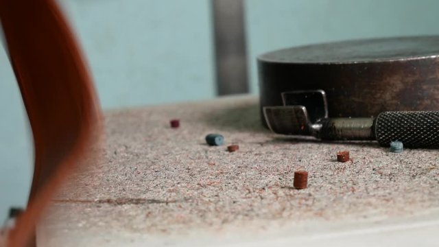 Leather master makes holes in leather for fittings, rivets. Using a chisel and a hummer in order to puncture leather. Handmade leather manufacture 4k