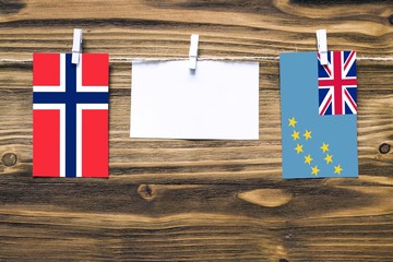 Hanging flags of Bouvet Islands and Tuvalu attached to rope with clothes pins with copy space on...