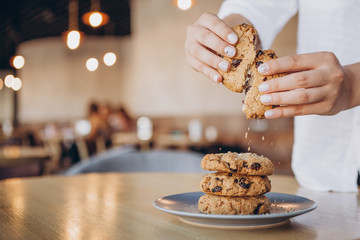 close up photo of delicious and crunchy oatmeal cookies on the backdrop of a cozy restaurant or bakery interior, festive Christmas mood, 4 cookies lying on top of each other - obrazy, fototapety, plakaty