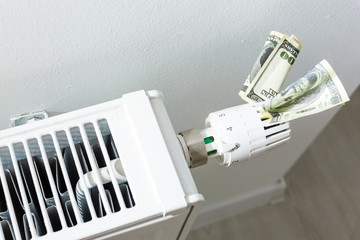 heating thermostat with money, dollar, expensive heating costs concept
