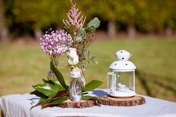 Outdoors wedding decoration with flowers and a lantern