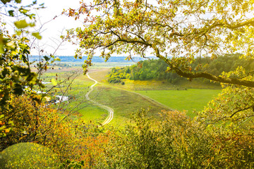 Autumn field from the hill. Road in the nature. Beautiful landscape with a river.