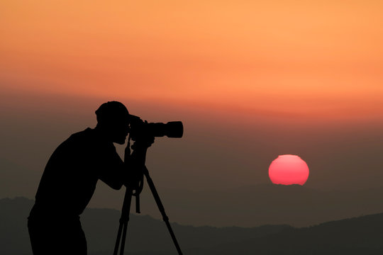 Man Silhouette Photographer take photo on hill high mountain professional camera shooting photo landscape sunset on top mountain nature twilight sky background.