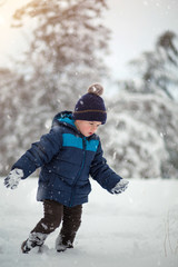 Fototapeta na wymiar Adorable, cute boy playing with snow cheerfully