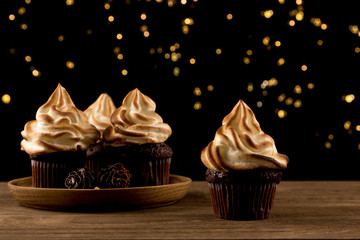 Cupcake. Delicious Christmas Chocolate cupcake on dark bokeh lights background, close up