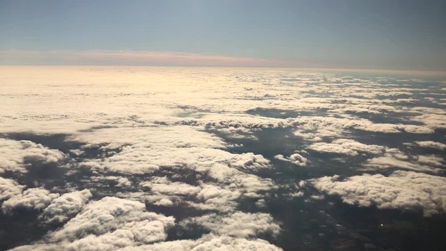 4K HD video flying over thick cloudscape, view from above from inside an airplane.