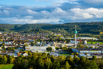 Germany, Wide aerial view over skyline of beautiful city schorndorf surrounded by green forested hills in warm sunset light