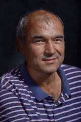 Portrait of a young tanned Asian man on a black background