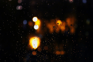 Rain splashes on the window and the night lights of the city.