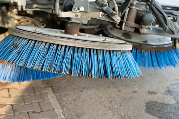 Fragment of a street sweeper. Large round brushes are located at the front of the car. Selective...