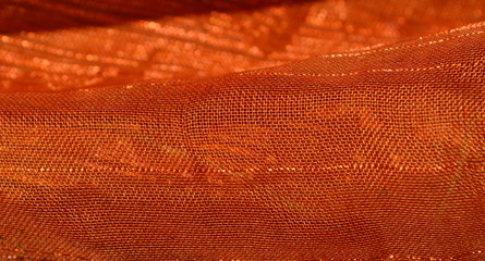 the texture of the background of the nylon fabric with iridescence from yellow to light brown