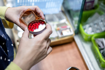 Close up of female hand pouring red medicines from a bottle into a lid. Pharmacist prepare drugs for patient