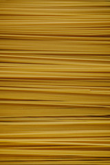 Yellow long spaghetti on a black background. Yellow Italian pasta. Long spaghetti. Raw spaghetti bolognese. Raw spaghetti. Food concept background. Italian food and menu concept.