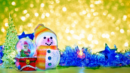 Christmas props decorations, little Santa claus, snowman and Christmas tree with blurred bokeh of christmas decorative lights background at night time , Merry Christmas and happy new year concept 
