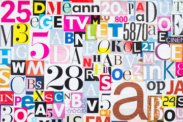 Abstract collage of pieces of colorful magazine paper with letters and numbers.