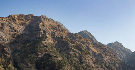Low angle shot of high mountain peak with morning sun hitting it. Tiny hills concept
