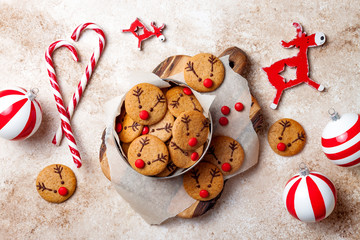 Cooking Christmas gingerbread. Decorated red nosed reindeer cookies with chocolate buttons and...
