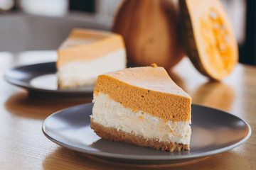 Slices of Freshly Baked Pumpkin Pie on cozy cafe background, selective focus, noise effect