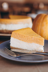 Piece of pumpkin homemade cake. Festive dessert concept. pumpkin tart on cozy cafe background, selective focus, noise effect