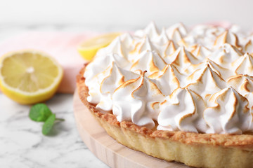 Serving board with delicious lemon meringue pie on white marble table, closeup