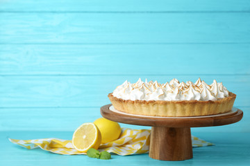 Stand with delicious lemon meringue pie on blue wooden table, space for text - obrazy, fototapety, plakaty