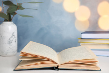 Open hardcover book on table against blurred background