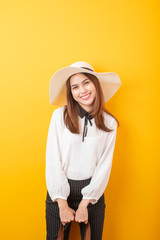 Beautiful traveler woman is exciting on yellow  background