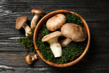 Flat lay composition with fresh wild mushrooms on black wooden table