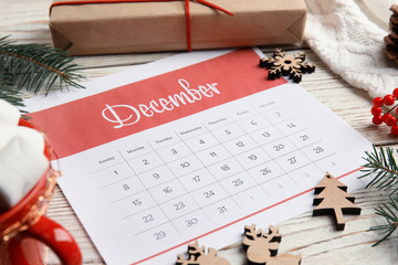 Paper calendar and festive decor on wooden table
