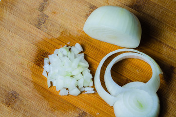 White onion on a wooden board. vegetable slicing process. cooking food