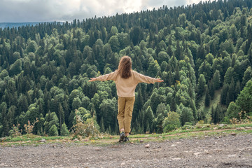 Tourist girl looks at the forest