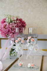 two wedding glasses close up on the background of the bride's bouquet