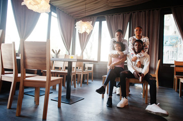 Happy african friends sitting and chatting in cafe. Group of black peoples meeting in restaurant.