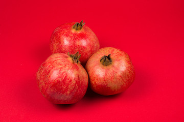 Sweet pomegranate on red background.