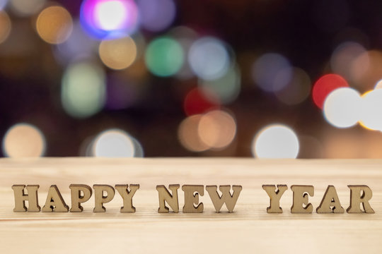 Happy new year on wood and blurred background
