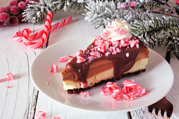 Christmas holiday candy cane chocolate cheesecake. Side view scene with a white wood background.