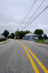 View of an almost empty US road seen entering a small US town with some distant cars as seen in early autumn.