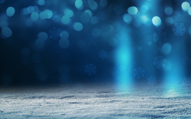 Winter abstract, blurred background with bokeh. Blurry night city lights in reflection on a snowy road. Neon light, falling snow, snowflakes.