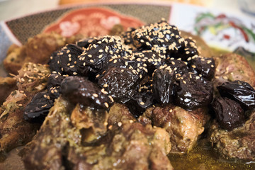 Meat with prunes, onions and sprinkled with sesame seeds, Moroccan tagine, Slow cookingprocess rustic cultural style.
